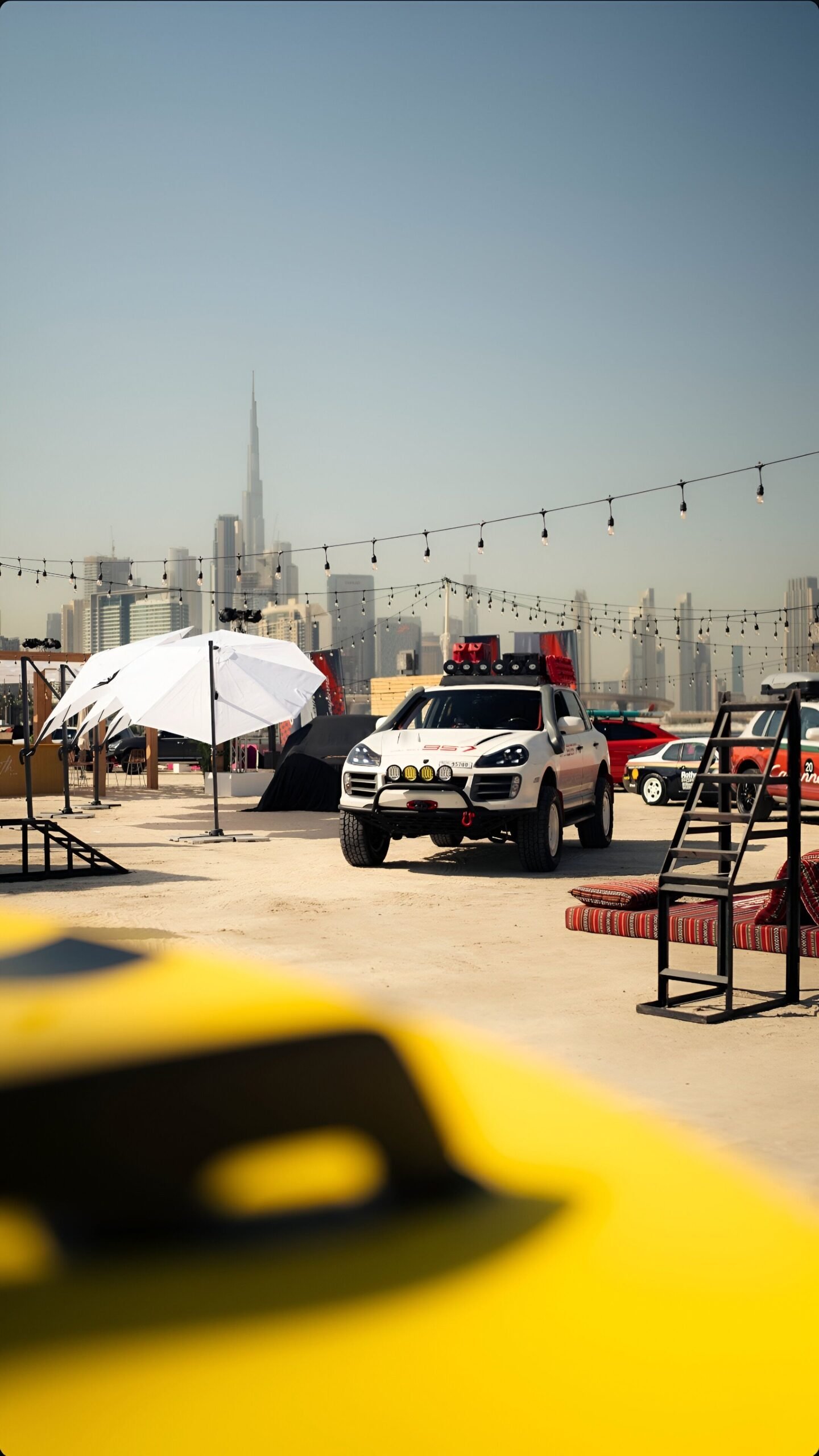 Rooftop car event with modern buildings and city skyline in the background.