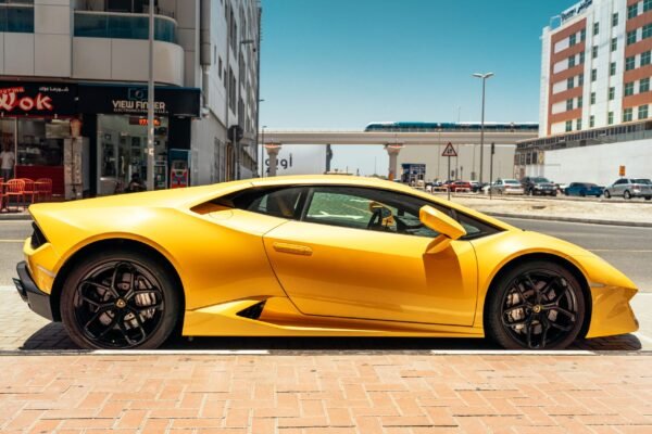 Sleek yellow sports car parked on a sunny day in the vibrant streets of Dubai.
