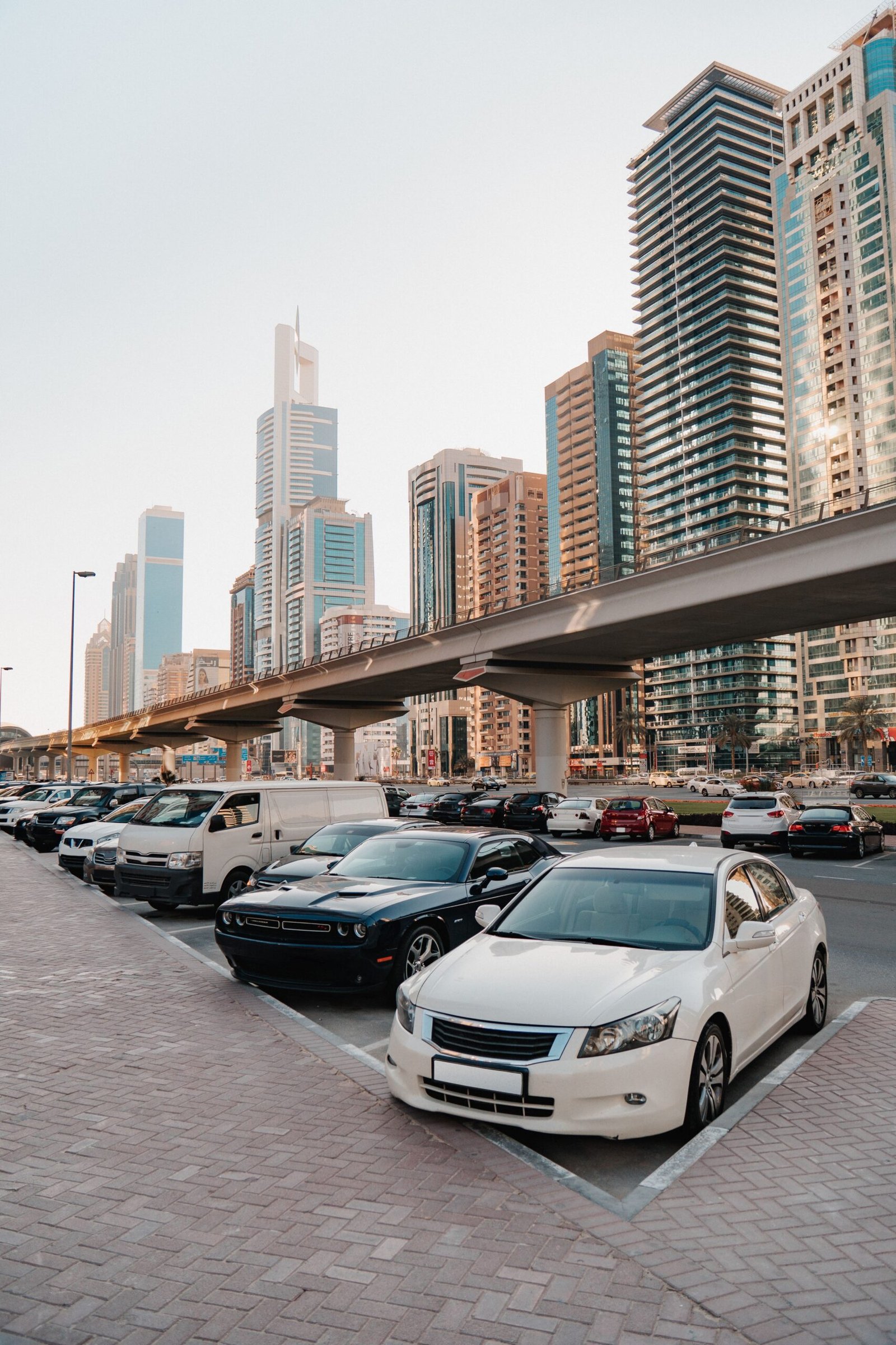 Cityscape with high-rise buildings and cars parked in a busy urban setting.